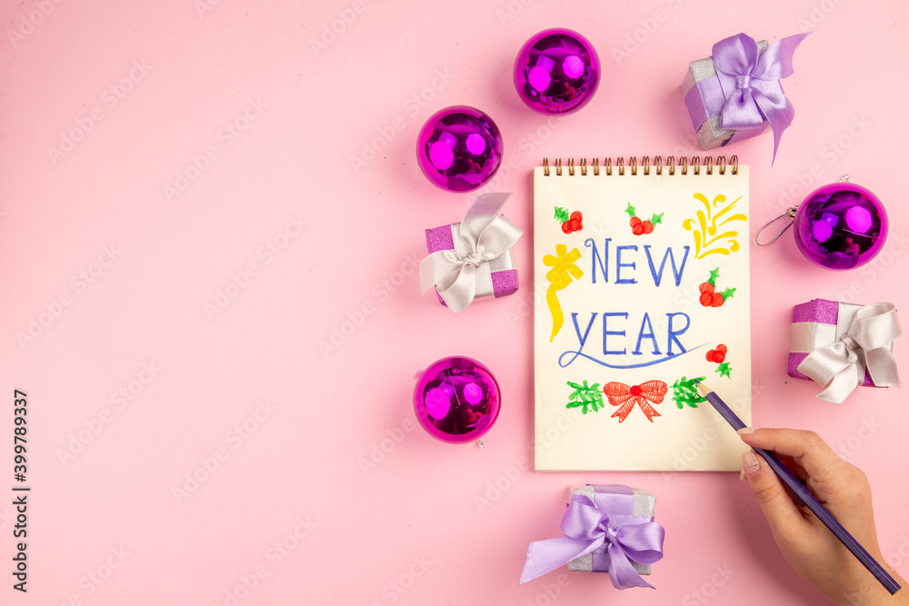Obraz premium top view cute little presents with xmas tree toys and new year note on pink background gift color new year christmas photo