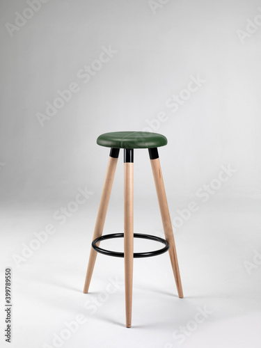 Wooden stool with leather seat on a neutral background