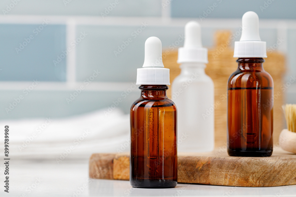 Glass cosmetic oil bottles with pipette in bathroom Glass cosmetic oil bottles with pipette in bathroom