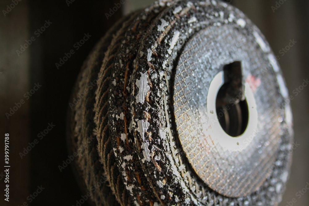 Used cutting wheel with macro detail of worn areas where metal is polished. Industrial work tools.