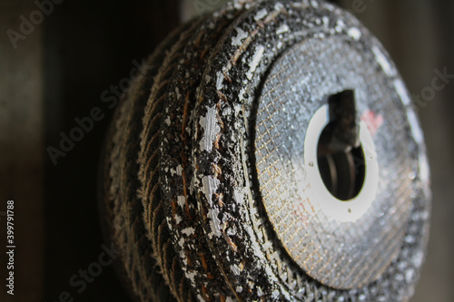 Used cutting wheel with macro detail of worn areas where metal is polished. Industrial work tools.