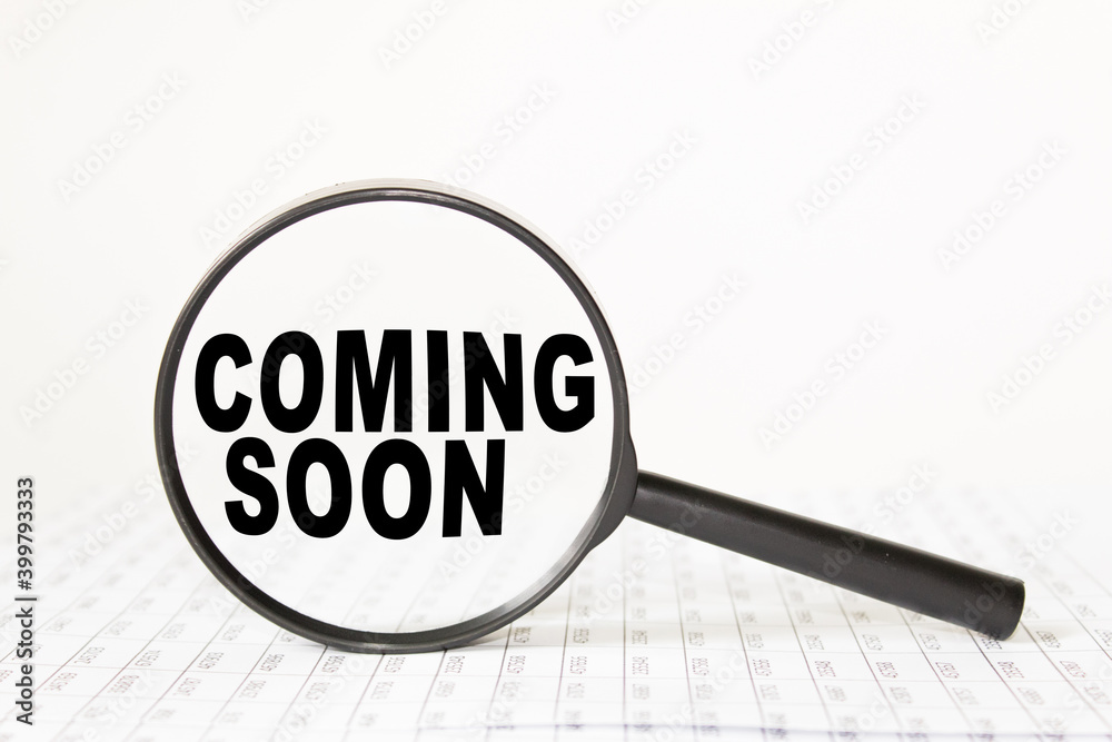 words COMING SOON in a magnifying glass on a white background. business concept words COMING SOON in a magnifying glass on a white background. business concept