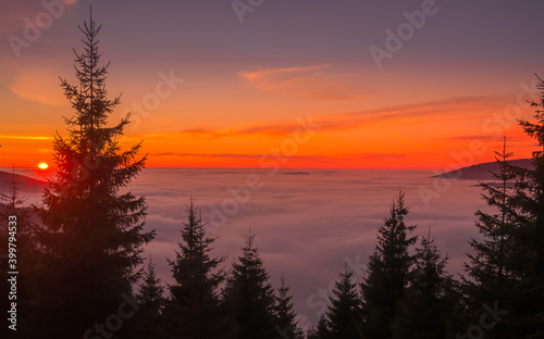 View from mountain range to the valley above fog and clouds at sunset © Jansk