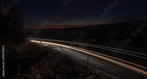 Car light lines on a mountain asphalt road in the evening
