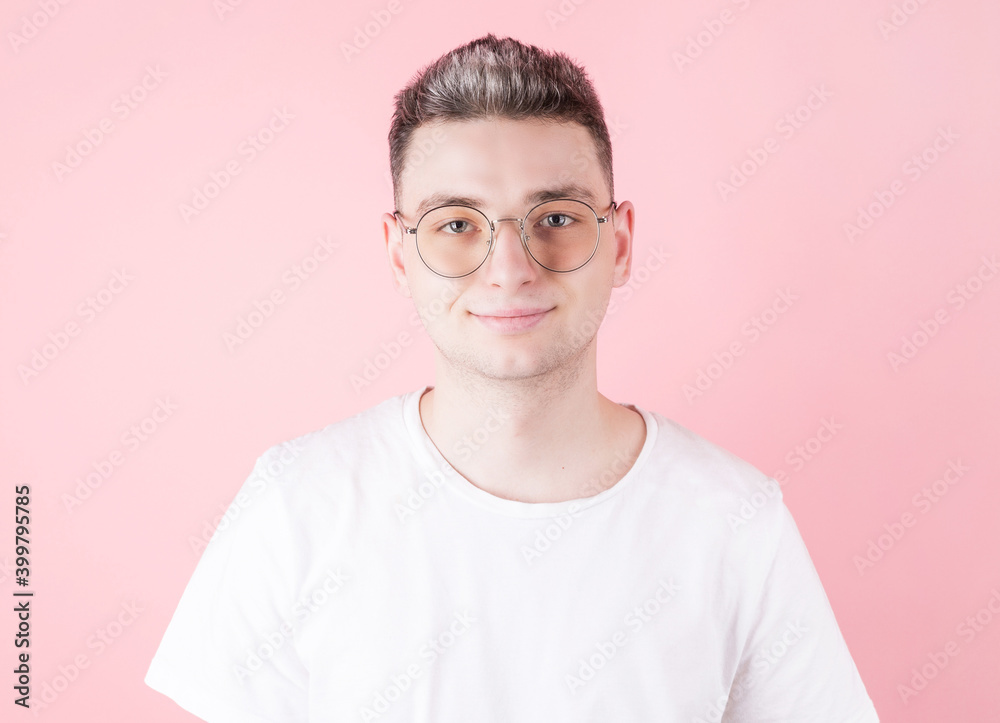 Handsome young caucasian man smiling at camera on pink background Handsome young caucasian man smiling at camera on pink background