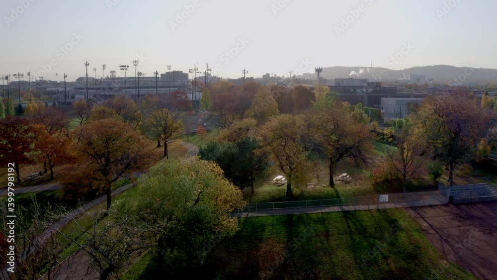 Drone descending over a public parc on a autumn sunny morning