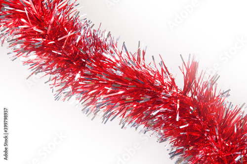 Red tinsel and a white background. Christmas preparation