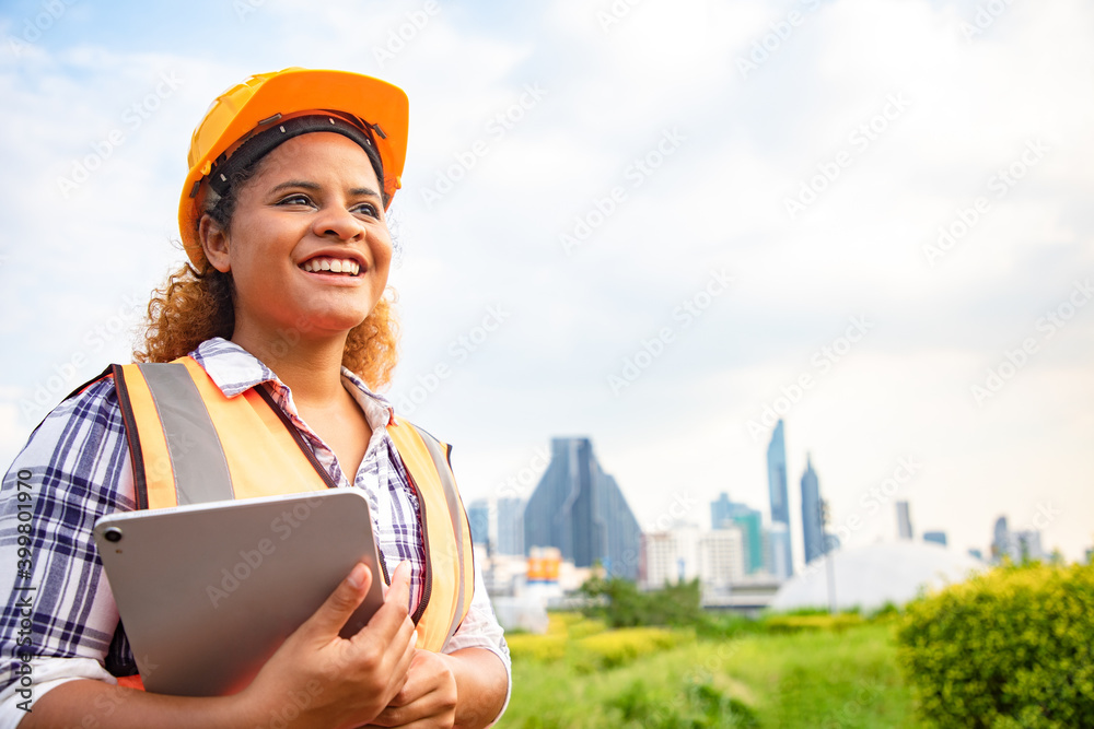 Portrait of woman architect standing and using tablet for check project and statistical report on site. Back view of contractor on background of modern office buildings with blue sky. Portrait of woman architect standing and using tablet for check project and statistical report on site. Back view of contractor on background of modern office buildings with blue sky.