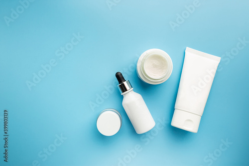 Flat lay composition with skin care products on blue background