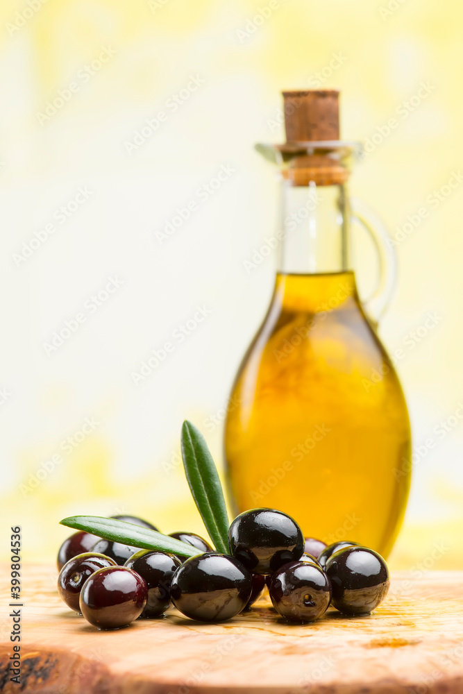 extra virgin olive oil with black olives on olive board extra virgin olive oil with black olives on olive board