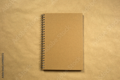 recycled brown paper blank notebook front cover with brown background texture top view, copy space, space for text modern design, business or education concept