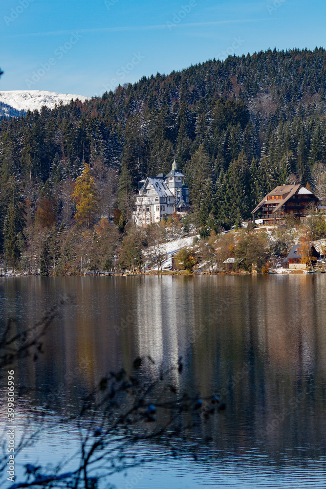 Titisee-Neustadt, Germany - 10 30 2012: beautiful white house castle on the coast of Titisee, european village in beautiful winter cold day. House reflected in the lake