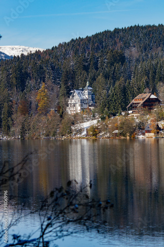 Titisee-Neustadt, Germany - 10 30 2012: beautiful white house castle on the coast of Titisee, european village in beautiful winter cold day. House reflected in the lake