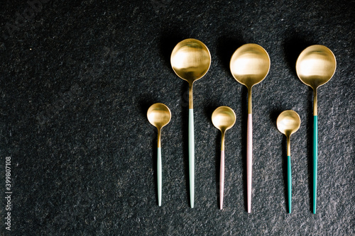 set of stylish colored spoons on a black background. Modern kitchen. Restaurant food