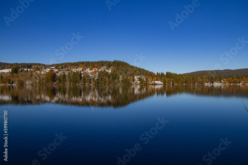 Titisee-Neustadt, Germany - 10 30 2012: surroundings of Titisee, european village in beautiful winter cold day. Scenery is reflected in the lake. 
