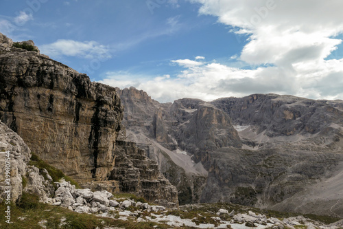 Panoramic view on the valley in Italian Dolomites. The bottom of the valley is overgrown with small plants. In the back there is a high mountain chain, with very sharp slopes. Serenity and recharging © Chris