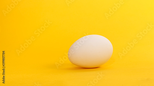 Organic chicken eggs on yellow background.