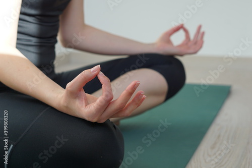 Young woman doing yoga on floor at home.