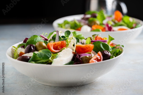 Fresh green salad with cherry tomato, mozzarella and olives.