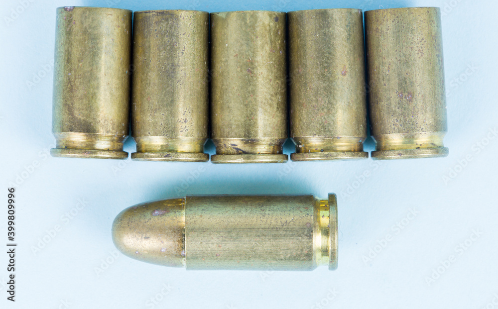 fired bullets, bullet casings photographed up close on a blue background, pistol bullet fired bullets, bullet casings photographed up close on a blue background, pistol bullet