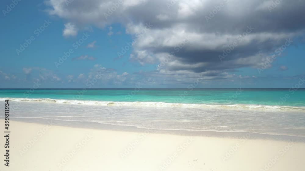 Exotic beach by the ocean with rolling waves on the sandy shore and blue sky Exotic beach by the ocean with rolling waves on the sandy shore and blue sky