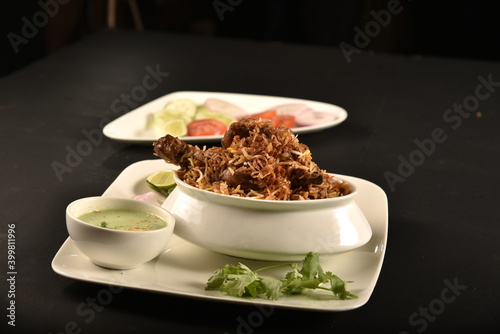 mutton biryani of bengal served with salad and raita photo