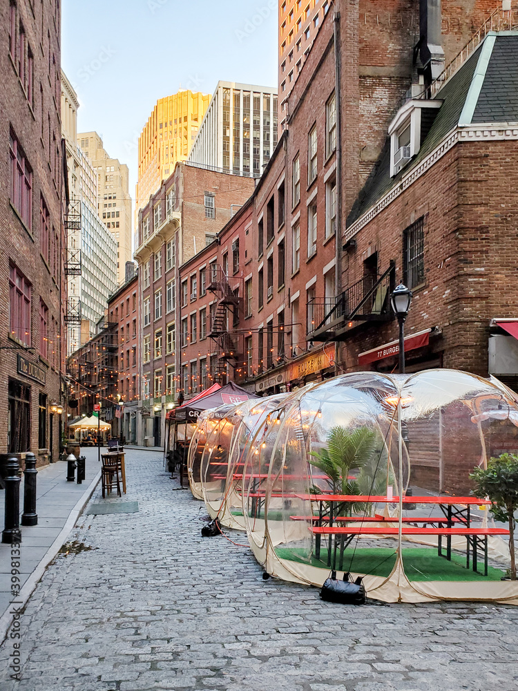 New York City, USA - 2020: Outdoor dining tables in front of the historic buildings on Stone Street during the coronavirus pandemic in downtown Manhattan