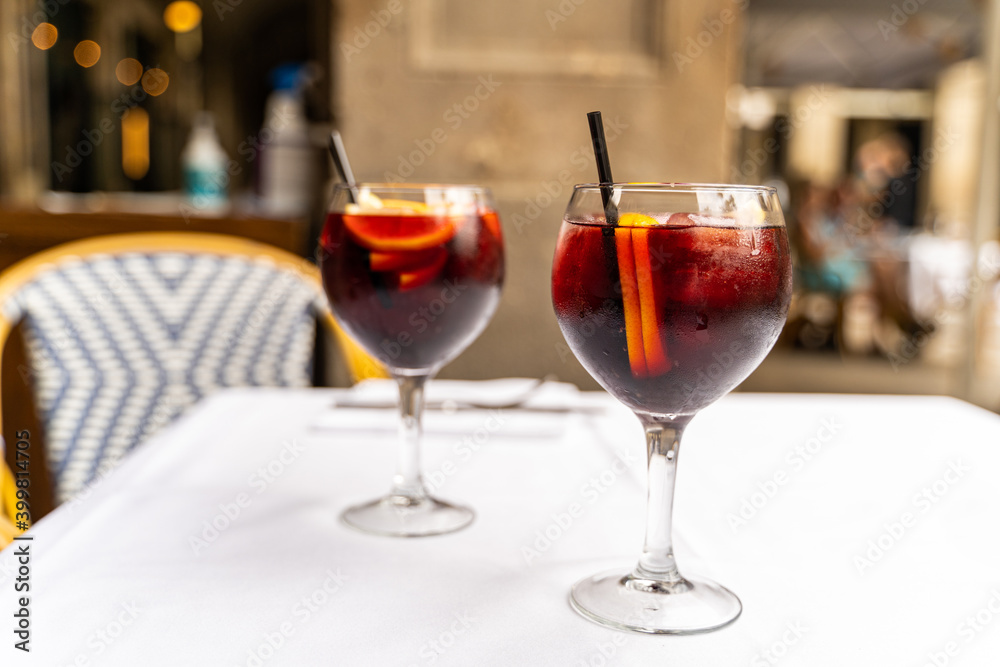 Two red sangria glasses on white tablecloth in restaurant Two red sangria glasses on white tablecloth in restaurant