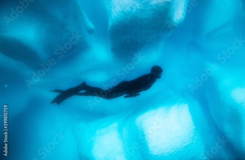 Freediver near iceberg in Antarctica