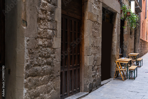 Cafe with terrace on a narrow street with medieval historic houses in Barcelona