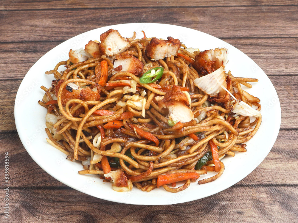Chicken Noodles a popular indo chinese dish made with chicken, noodles and vegetables, served over a rustic wooden background, selective focus Chicken Noodles a popular indo chinese dish made with chicken, noodles and vegetables, served over a rustic wooden background, selective focus