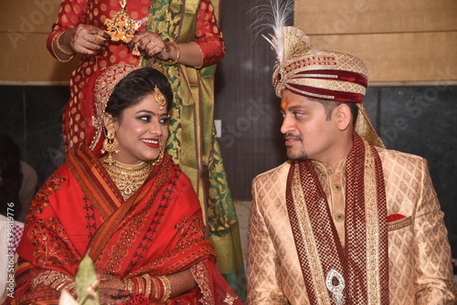 Bareilly, 2019 : Indian wedding couple enjoying and laughing during their marriage ceremony. Guests of different ethnicity can also be seen