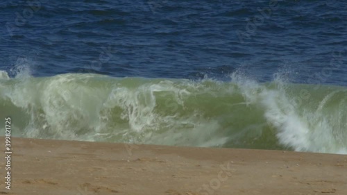 Wave breaks at shore on the sand sunny day, slow motion HD 96 fps