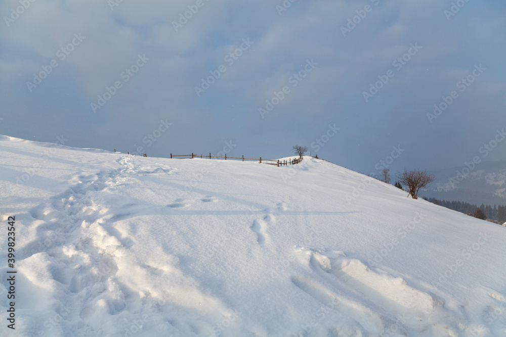 Deep snow on mountain slope, footprints on the snow. Ukraine, Carpathians.