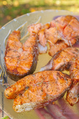 Grilled red fish trout steaks lie on a glass plate