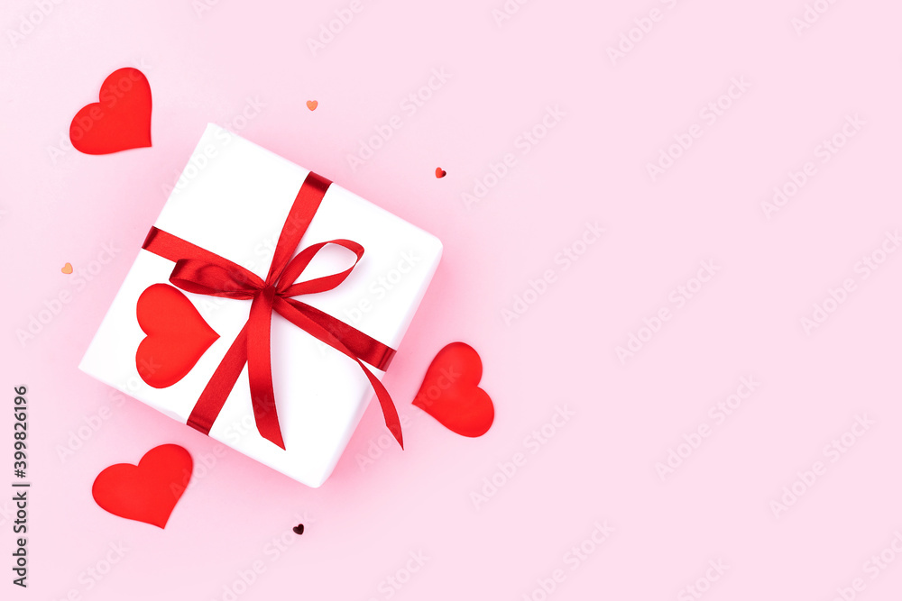 Background with gift, confetti, hearts on pastel pink background. Flat lay, top view. Valentines day concept. Mother's Day concept.