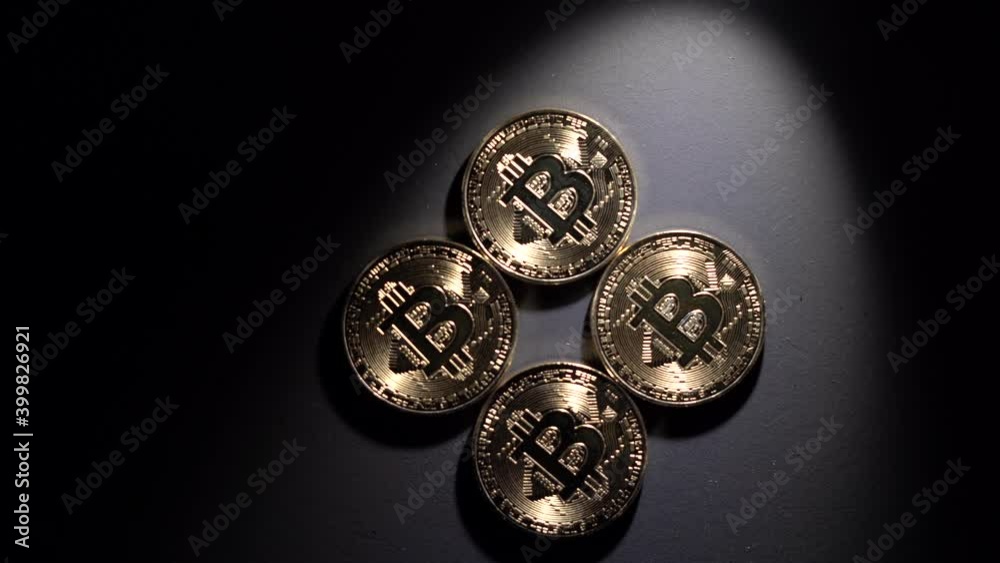 four bitcoin coins on a black background, a bud of light shines on them and plays brightly. four bitcoin coins on a black background, a bud of light shines on them and plays brightly.