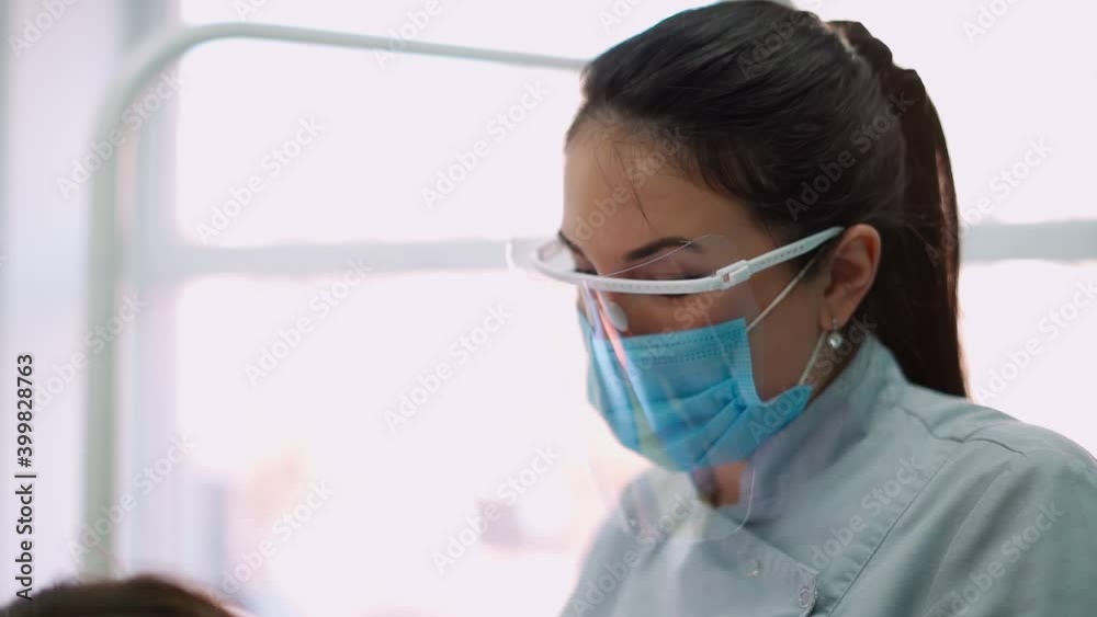 Woman Doctors in Protective Masks in a Dental Clinic, Serve the Female Patient. Work Dentist. Healthcare and Medicine Concept. Slow Motion. High quality FullHD footage Woman Doctors in Protective Masks in a Dental Clinic, Serve the Female Patient. Work Dentist. Healthcare and Medicine Concept. Slow Motion. High quality FullHD footage