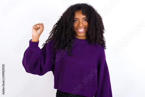 Young beautiful African American woman wearing knitted sweater against white wall pointing up with fingers number ten in Chinese sign language Shi © Roquillo