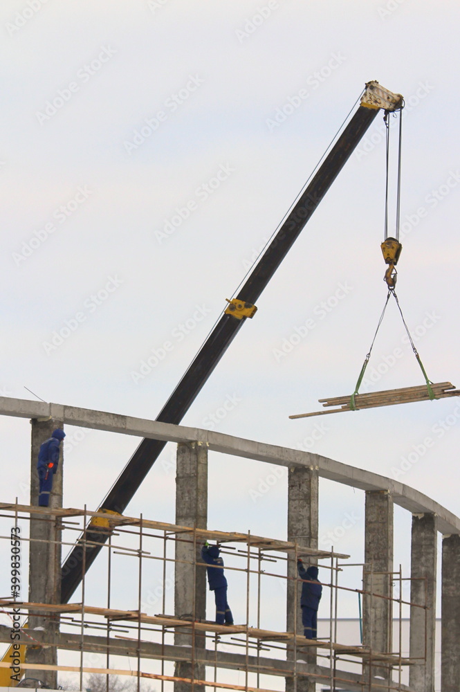 Builders working on a construction site, against the background of an industrial landscape. Builders working on a construction site, against the background of an industrial landscape.