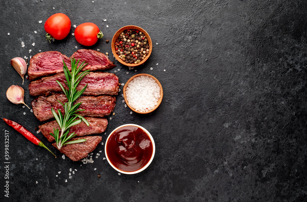 Different degrees of roasting beef steak in heart shape with spices on a stone background with a copy of the space for your text.