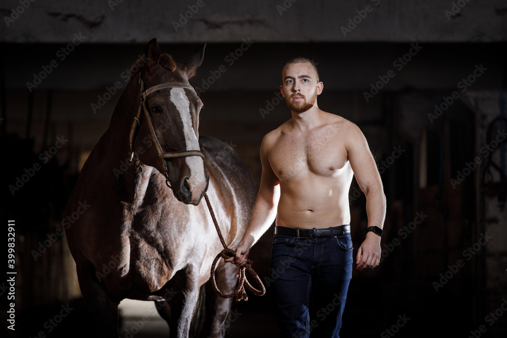 Obraz premium Young man with naked torso walking with horse
