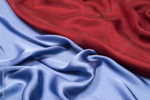 Red and blue silk or satin luxury fabric texture. Top view.
