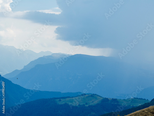 Beautiful view of the peaks of Monte Baldo. Stunning cloudy and panoramic view. Green Pastures in Italian Alps