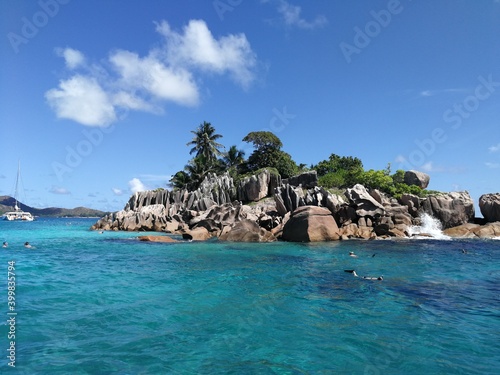 Blue water and cliffs and stones, white sandy beach, Seychelles