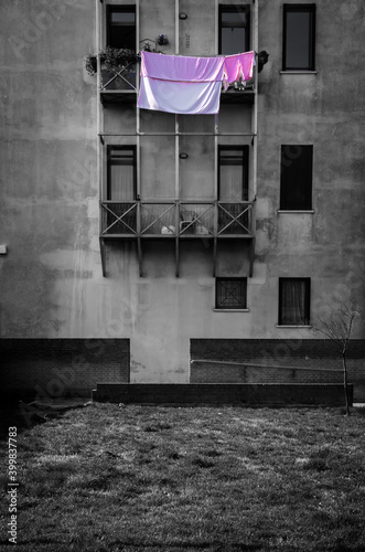 Obraz na plátně Panni rosa stesi ad asciugare su un balcone di una casa popolare