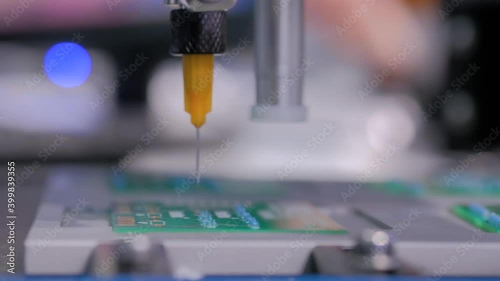 Automatic manipulator with dispenser needle dispensing solder paste on SMT computer circuit board - close up. Automated technology, industrial, robotic, electronic, production, manufacturing concept