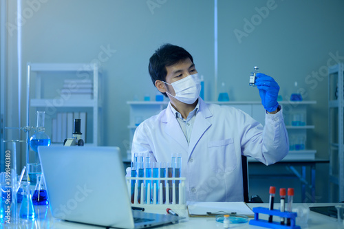 Scientist holding liquid chemical tube in laboratory, Science and technology healthcare concept