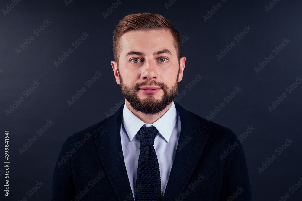 Portrait of handsome young businessman holding credit card over black background