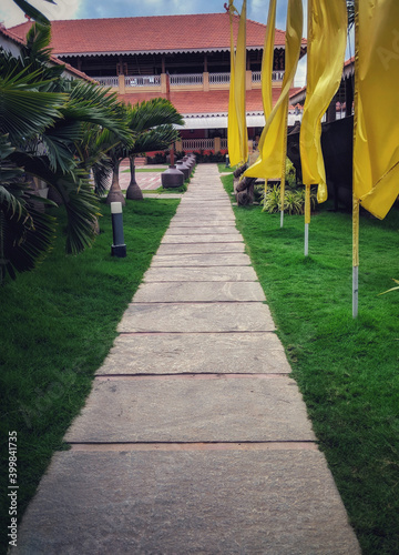 A beautiful path leading a lovely farm house under deep blue sky and lush green grass for fun and enjoyable holiday stay decorated in day light